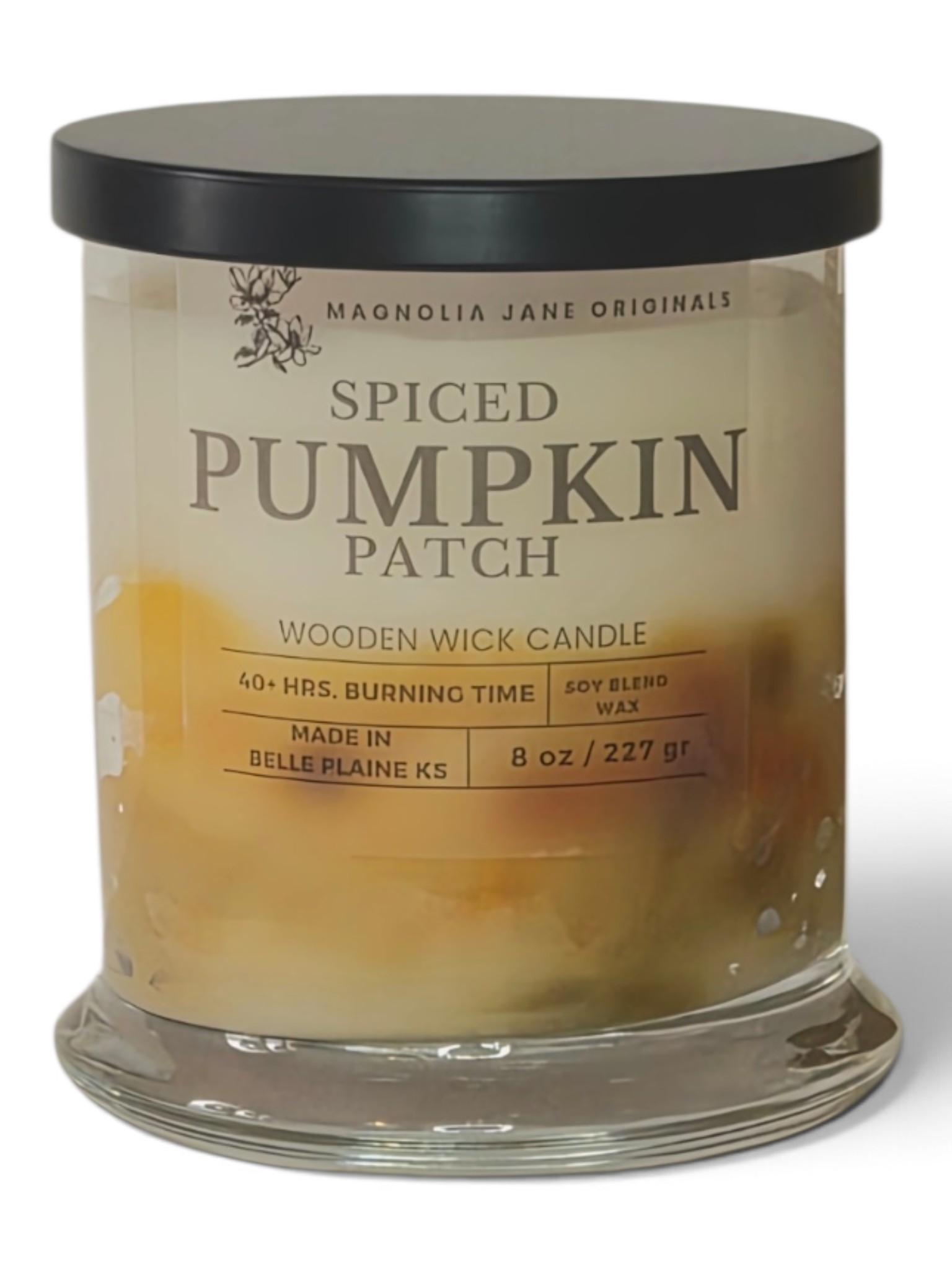 A Magnolia Jane Originals 'Spiced Pumpkin Patch' wooden wick candle in a clear glass jar with a black lid, filled with yellowish-amber wax showing layered pumpkin textures.
