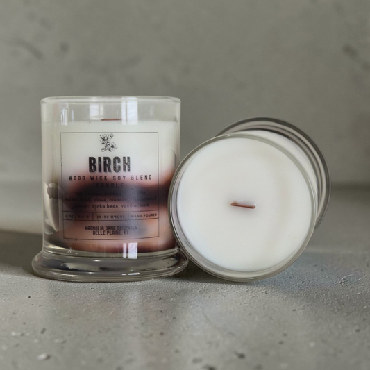 Birch  is a wooden wick candle that is a creamy white color with a swirl design on the lower half of the candle in tans and browns