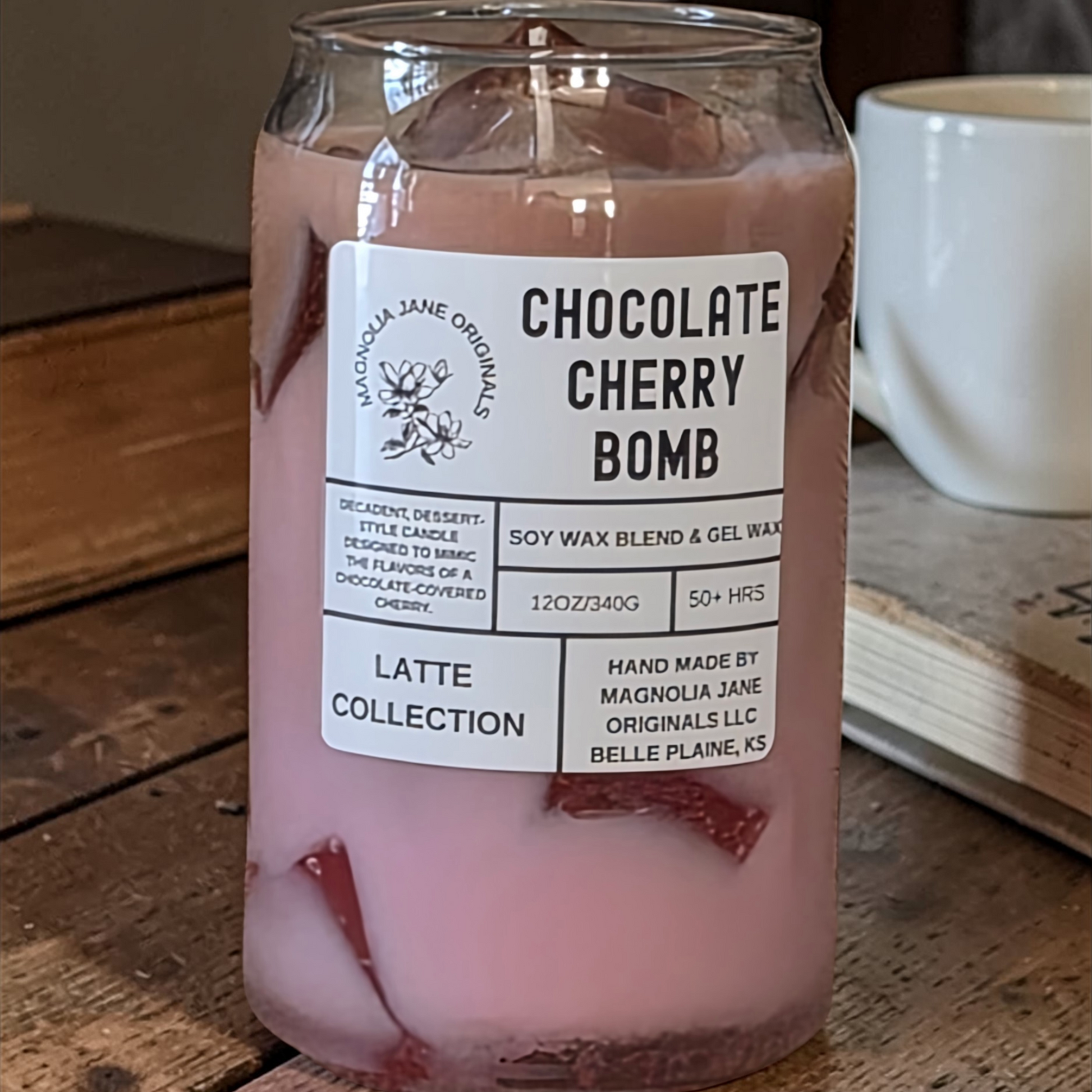 A tall glass with gel wax that appear to look like ice cubes.  The cubes glow when lit. The top third of the candle is a pale brown and the bottom 2/3 is a pale pink with a blend where they meet.