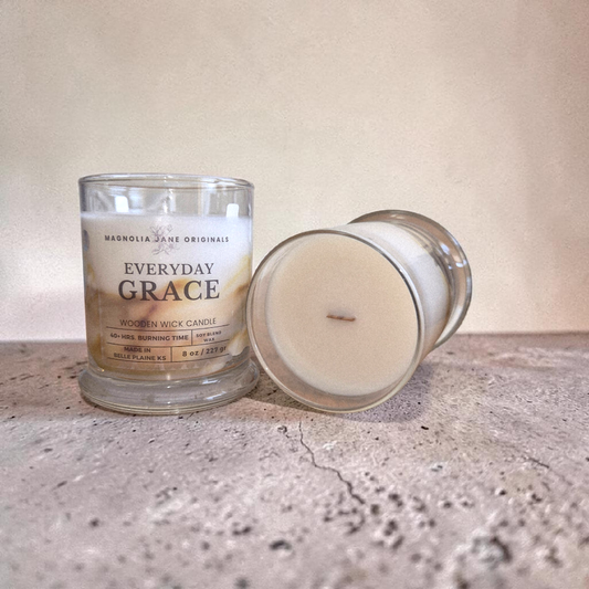 Two 'Everyday Grace' candles on a textured surface with a neutral background