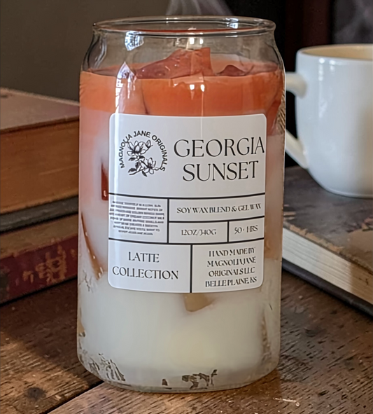 A tall glass with gel wax that appear to look like ice cubes.  The cubes glow when lit. The top third of the candle is a burnt orange and the bottom 2/3 is a creamy white with a blend where they meet.