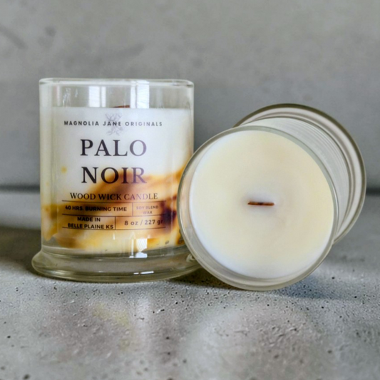 Palo Noir is a wooden wick candle that is a creamy white color with a swirl design on the lower half of the candle in creamy yellow & brown