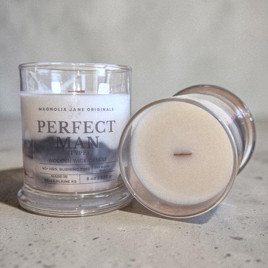 Two candles, one in a glass jar and one in a smaller container, on a neutral background.